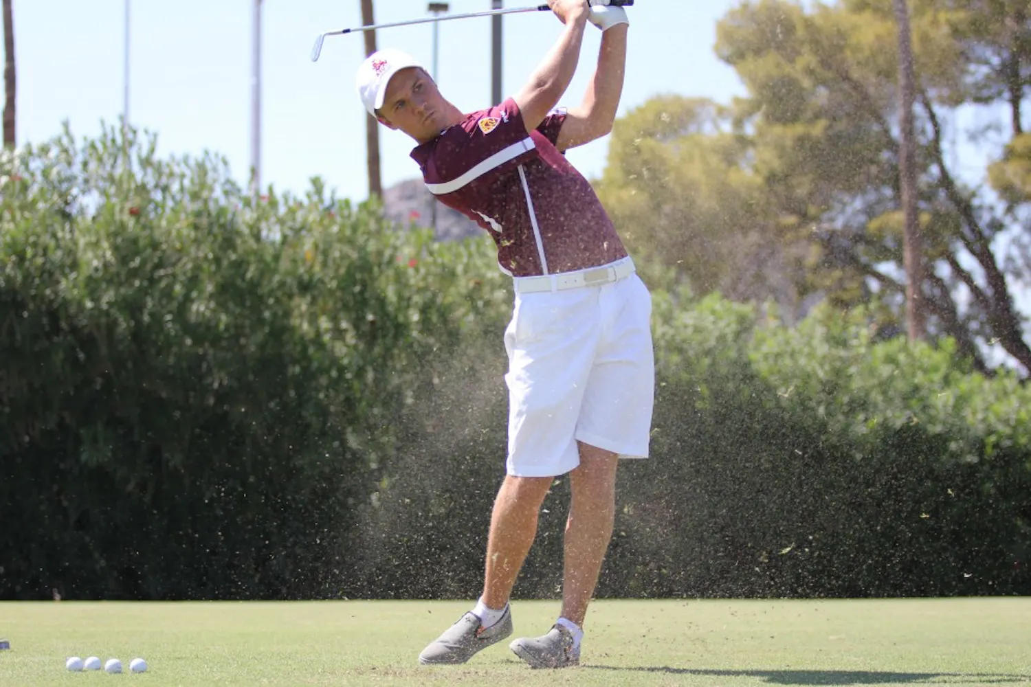 Sophomore Mathias Schjoelberg sprays some grass in front of him after finishing his swing. The men’s golf team finished tenth in the Amer Ari Invitational this weekend. (Photo by Kyle Newman)