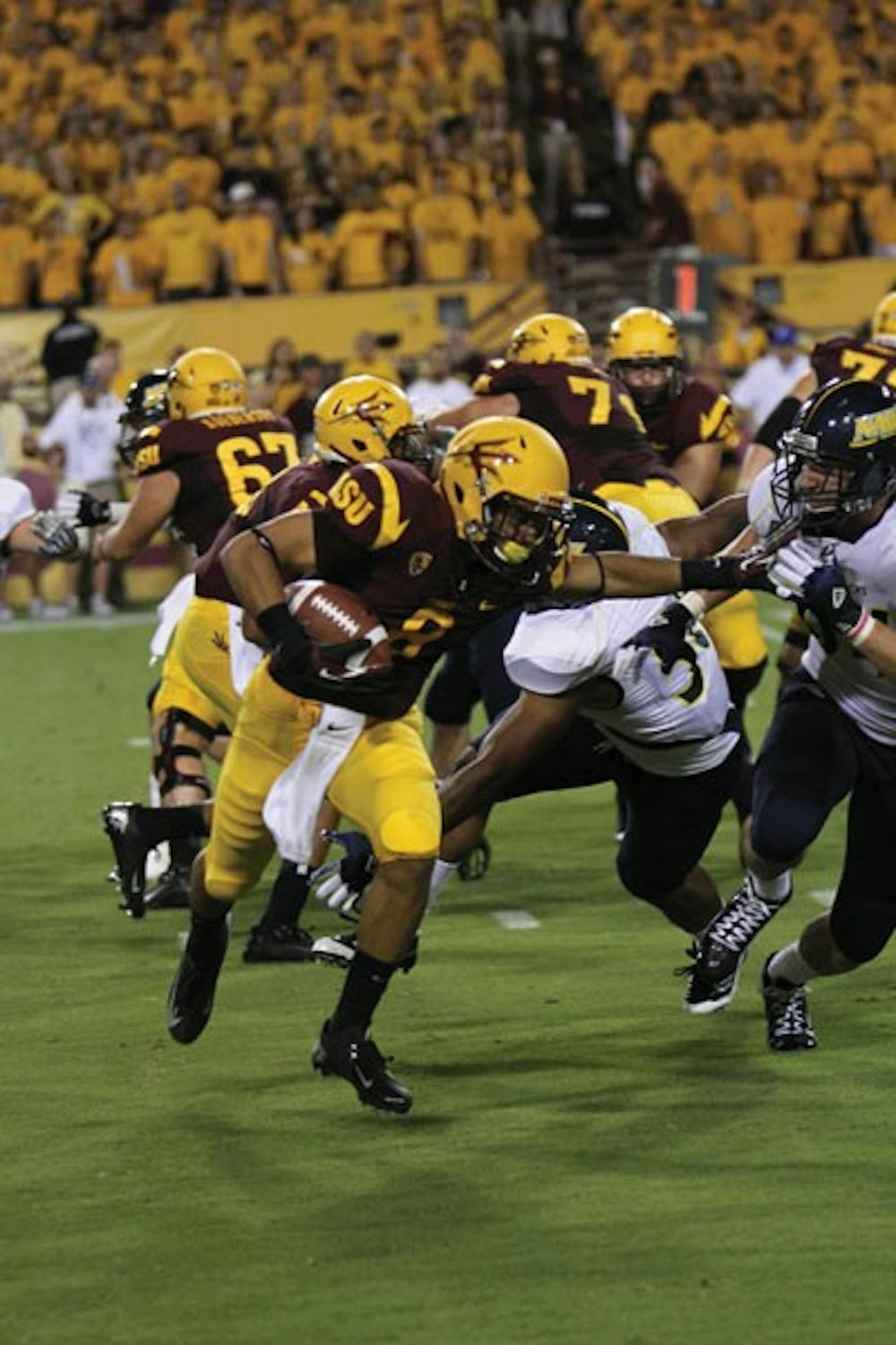 Freshman running back D.J. Foster (8) stiff-arms an NAU defender during the Sun Devils’ 63-6 win over the Lumberjacks on Sept. 30. (Photo by Vince Dwyer)