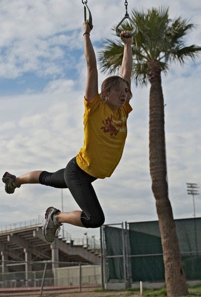 STRECHIN': Freshman pole vaulter Lina Kuenzi stretchers her limbs on the still rings during track practice at Sun Angel Stadium. (Photo by Michael Arellano)