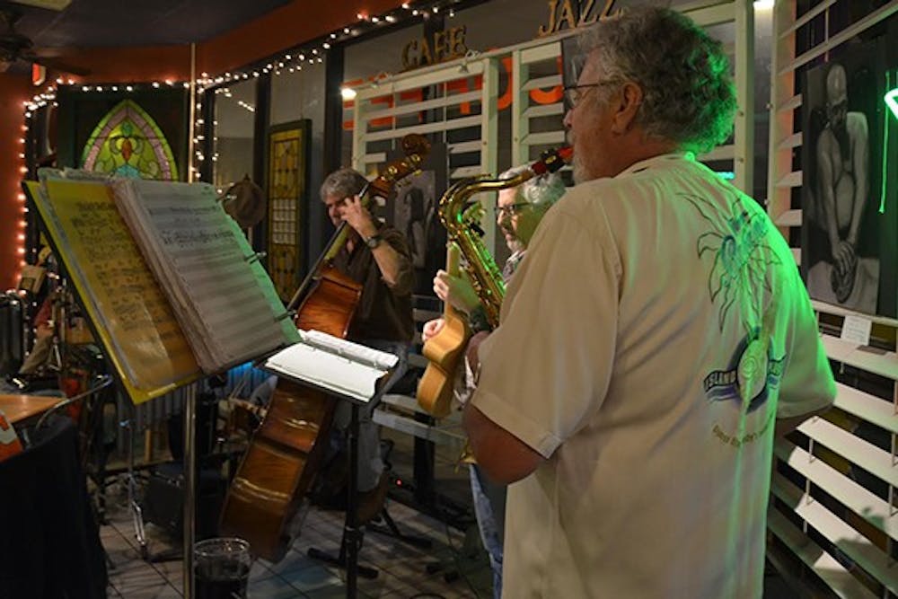 Gold Bar owner Dennis Miller plays the alto sax with Stan Ferris on guitar, Dan Meyer on the bass, and Rusty Falk on percussion (not pictured) on Friday, Jan. 10. Every Friday and Sunday night, the band plays jazz music at Gold Bar Espresso in Tempe. (Photo by Rachel Nemeh)