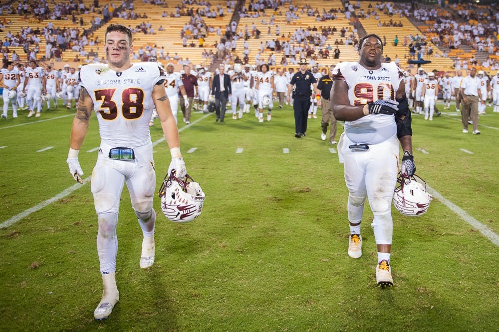 Redshirt senior safety Jordan Simone (38) and sophomore defensive lineman Tashon Smallwood take the field after a game against New Mexico on Friday, Sept. 18, 2015, at Sun Devil Stadium in Tempe. The Sun Devils defeated the Lobos 34-10.
