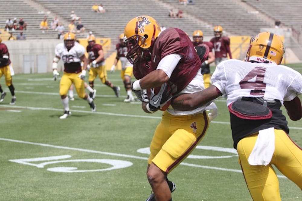 OVERWHELMING ADVANTAGE: ASU senior wide receiver Gerell Robinson tries to break a tackle by sophomore safety Alden Darby during ASU’s spring game in April. The Sun Devils’ speed across the board gives them a huge edge on UC Davis. (Photo by Beth Easterbrook)
