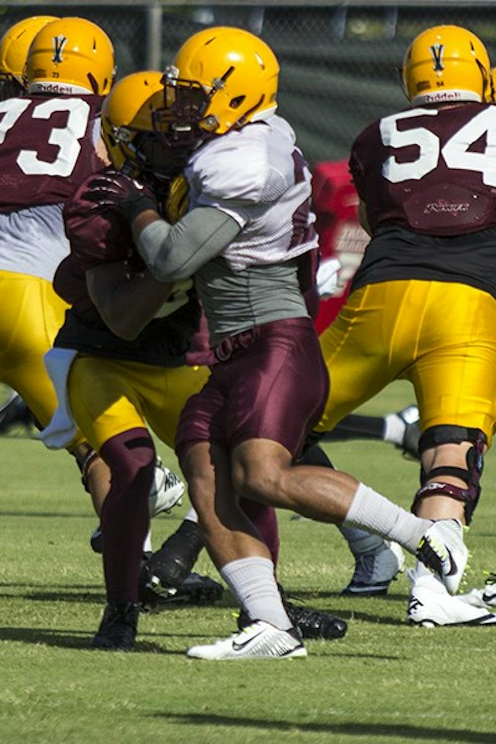 Redshirt sophomore linebacker Viliami Moeakiola pushes past the offensive line in a practice on Sept. 4, 2014. (Photo by Alexis Macklin)