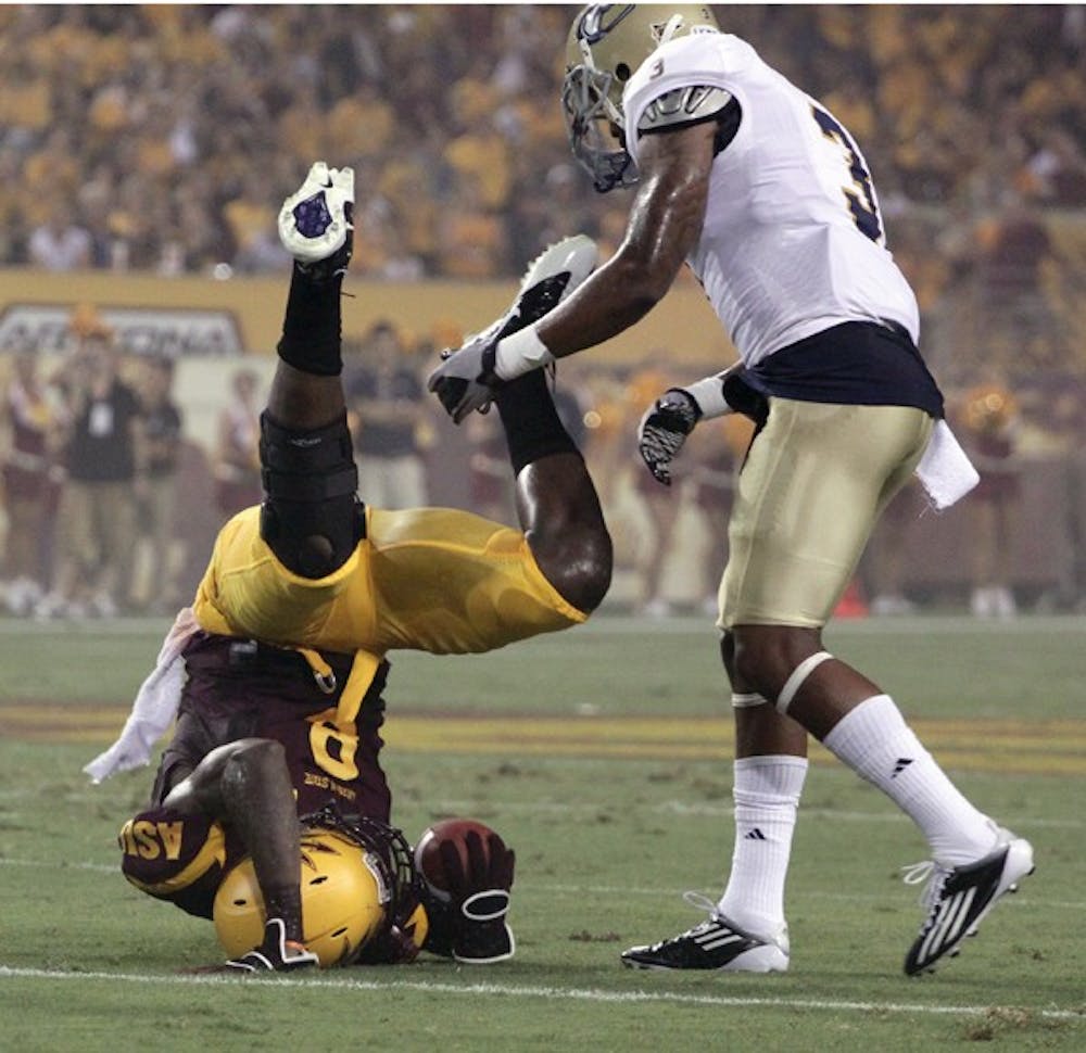 DOWN TO EARTH: ASU senior wide receiver Gerell Robinson crashes to the turf after making a catch against UC Davis. Robinson, like the rest of the Sun Devils, is amped up for Friday’s game. (Photo by Beth Easterbrook)