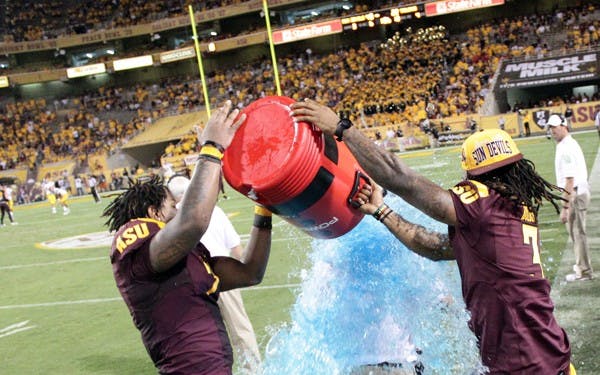 BLUE SHOWER: ASU junior linebacker Vontaze Burfict (left) and redshirt senior cornerback Omar Bolden dump the ceremonial Powerade on coach Dennis Erickson in the 4th quarter of the Sun Devils’ 43-22 upset over USC. (Photo by Beth Easterbrook)