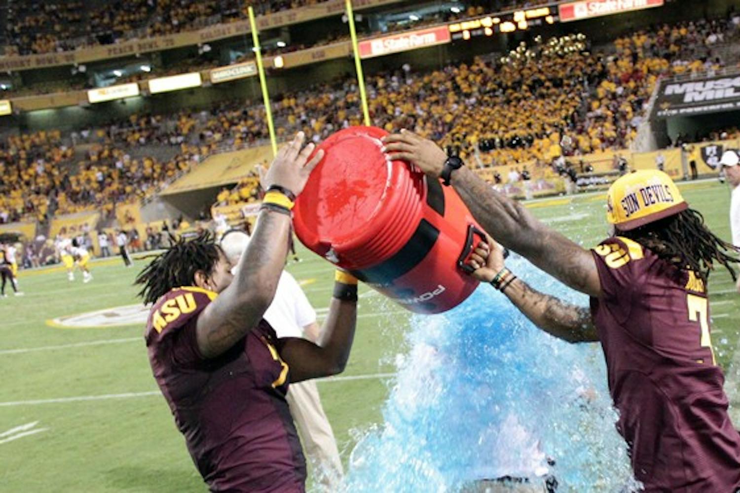 BLUE SHOWER: ASU junior linebacker Vontaze Burfict (left) and redshirt senior cornerback Omar Bolden dump the ceremonial Powerade on coach Dennis Erickson in the 4th quarter of the Sun Devils’ 43-22 upset over USC. (Photo by Beth Easterbrook)