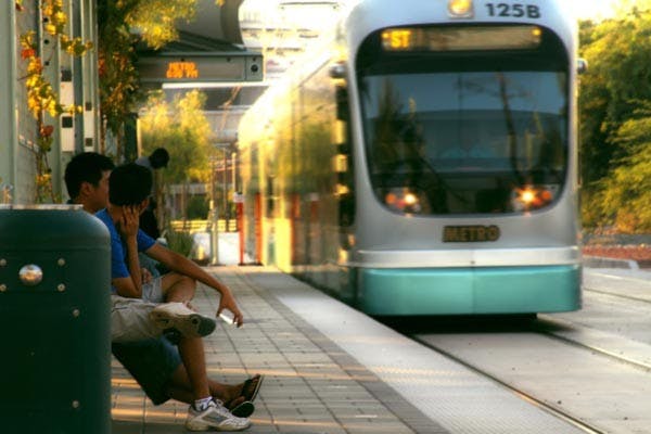 ASU students and workers await for their train ride home at one of the stops on the ASU campus. The parking and transit system is setting up a new system to help new students with any light rail questions. (Photo By Andy Jeffreys) 