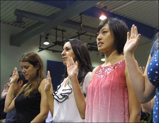 SERWAA ADU-TUTU | THE STATE PRESSBiochemistry alumnus Xiao Ping Li, right, makes her oath of allegiance during the 22nd Annual Independence Day Naturalization ceremony Friday at South Mountain Community College. 