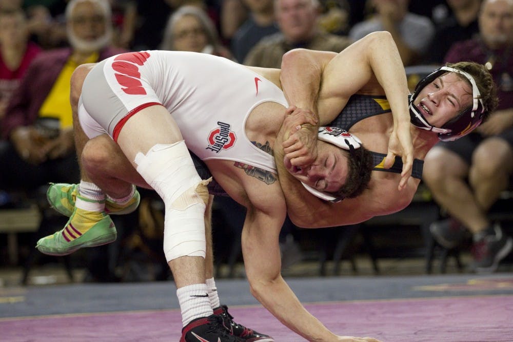 ASU redshirt freshman Josh Kramer (gray) keeps OSU wrestler Jose Rodriguez in a hold despite being in the air during the first match of a meet  in the first match of the meet versus the second ranked Ohio State University Buckeyes in Wells Fargo Arena in Tempe, Arizona on Saturday, Nov. 19, 2016. The Sun Devils lost the meet 15-27, and Kramer lost his match 0-13. 