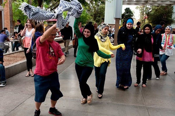 Student Noor Halloum and friends partake in a dabka dance outside the Memorial Union. The dance is commonly seen at social gatherings in Palestine. Students for Justice in Palestine hosted the event on March 6. (Photo by Mario Mendez) 