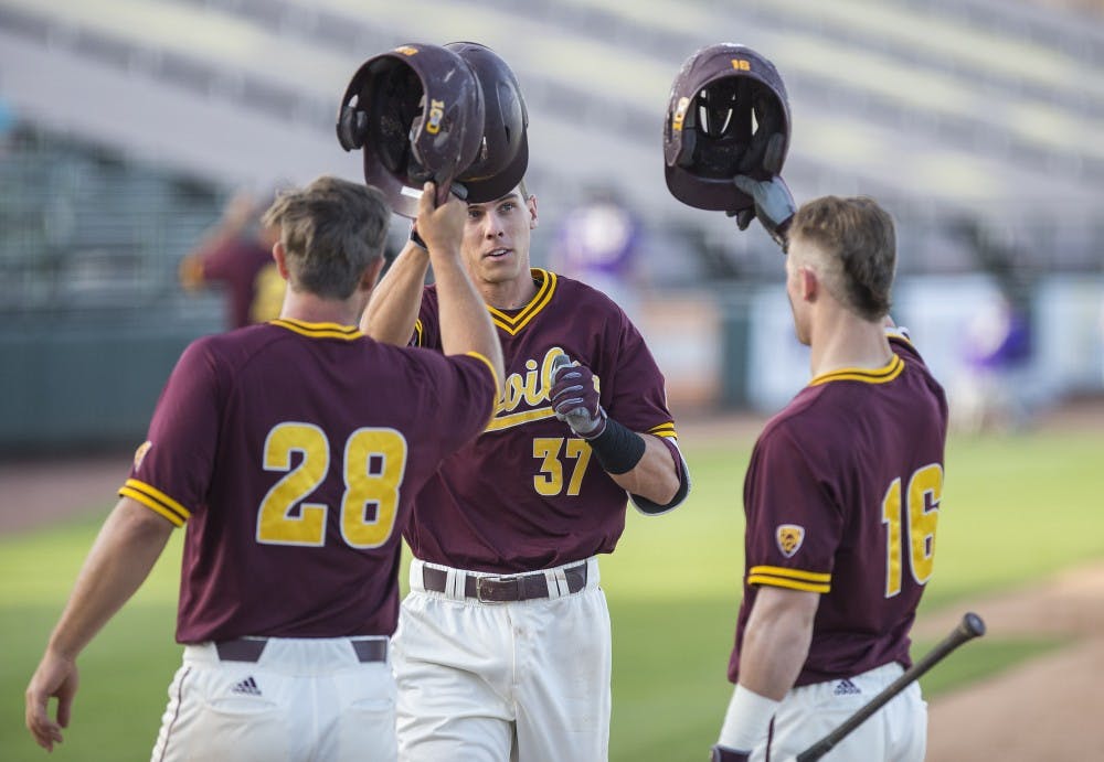 ASU shortstop Cody Woodmansee, center, celebrates with teammates after hitting a home-run during a game against the University of Washington Huskies at Phoenix Municipal Stadium in Phoenix, Arizona, on Saturday, April 9, 2016. The Sun Devils won the game, 6-3. 