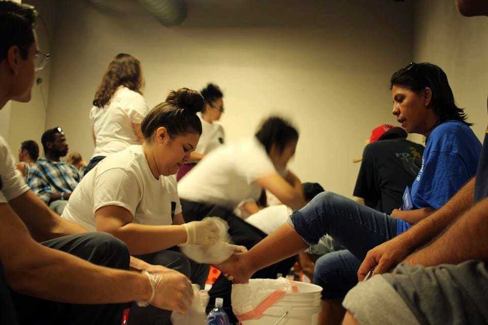 Volunteers wash the feet of homeless individuals at a Bakpak event.