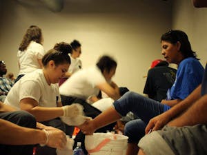 Volunteers wash the feet of homeless individuals at a Bakpak event.