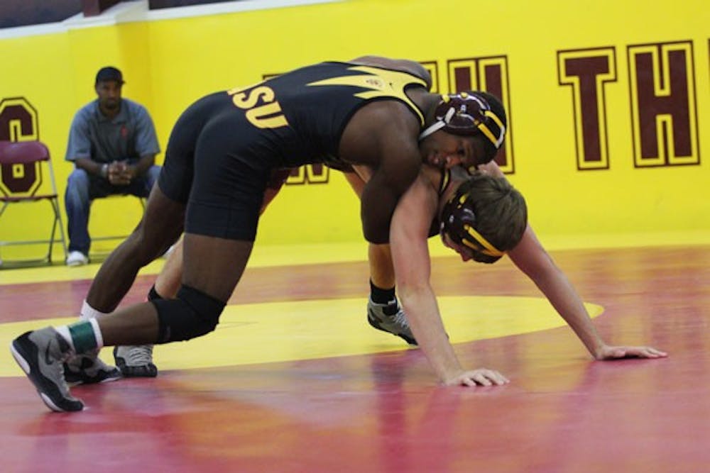 Redshirt sophomore 184-pound wrestler Kevin Radford (left) wraps up redshirt senior Jake Meredith during the Sun Devils’ Maroon and Gold Wrestle-Offs on Oct. 26. (Photo by Kyle Newman)