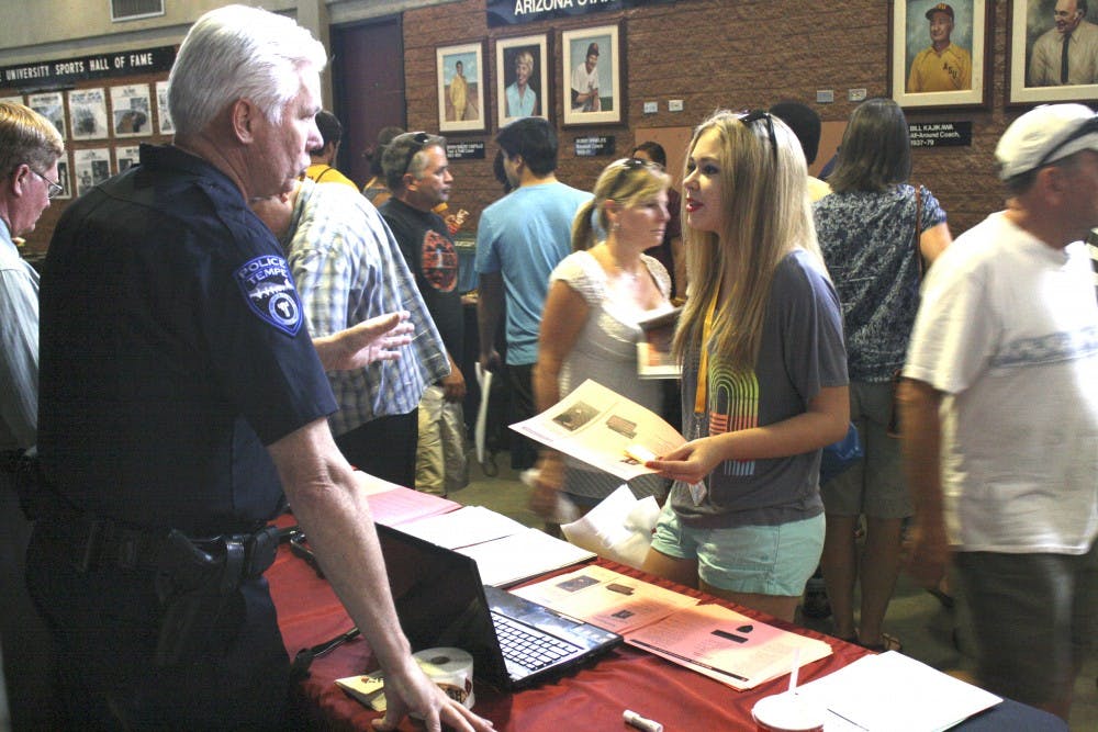 Tempe PD Crackdown #2: Detective Jeff Lane with Tempe Police Department's Crime Prevention Unit talks to animal psychology major Abby Howard about the different measures and precautions to help ensure ASU students are safe on and off campus. The Tempe Police Department's Crime Prevention Unit tabled at the Freshman move in on Aug. 17 and 18. (Photo by Hector Salas Almeida)
