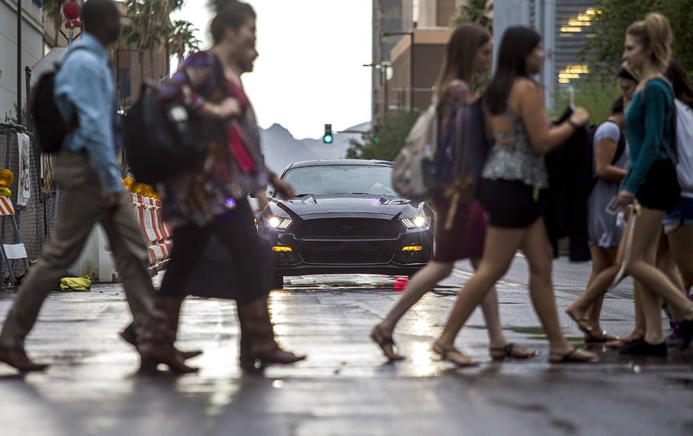 ASU students walk past a car while crossing 1st Street near the Downtown campus on Tuesday, Oct. 6, 2015.