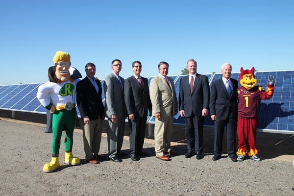 SOLAR MEN: Speakers pose with Solar Man and Sparky by the solar field outside of the West Campus Tuesday morning, which just achieved 10 megawatts of solar-generated capacity. (Photo by Rosie Gochnour)