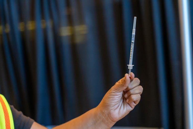 Site Director Melissa Irizarry holds up a syringe containing a dose of the Pfizer COVID-19 vaccine at the Gila River Arena vaccine site in Glendale on Tuesday, May 18, 2021.