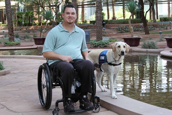 MAN'S BEST FRIEND: Bill Weigt smiles alongside his 3-year-old service dog Zeus.  Weigt was paralyzed from the chest down during a shooting while on duty in 2005. (Photo by Lisa Bartoli)