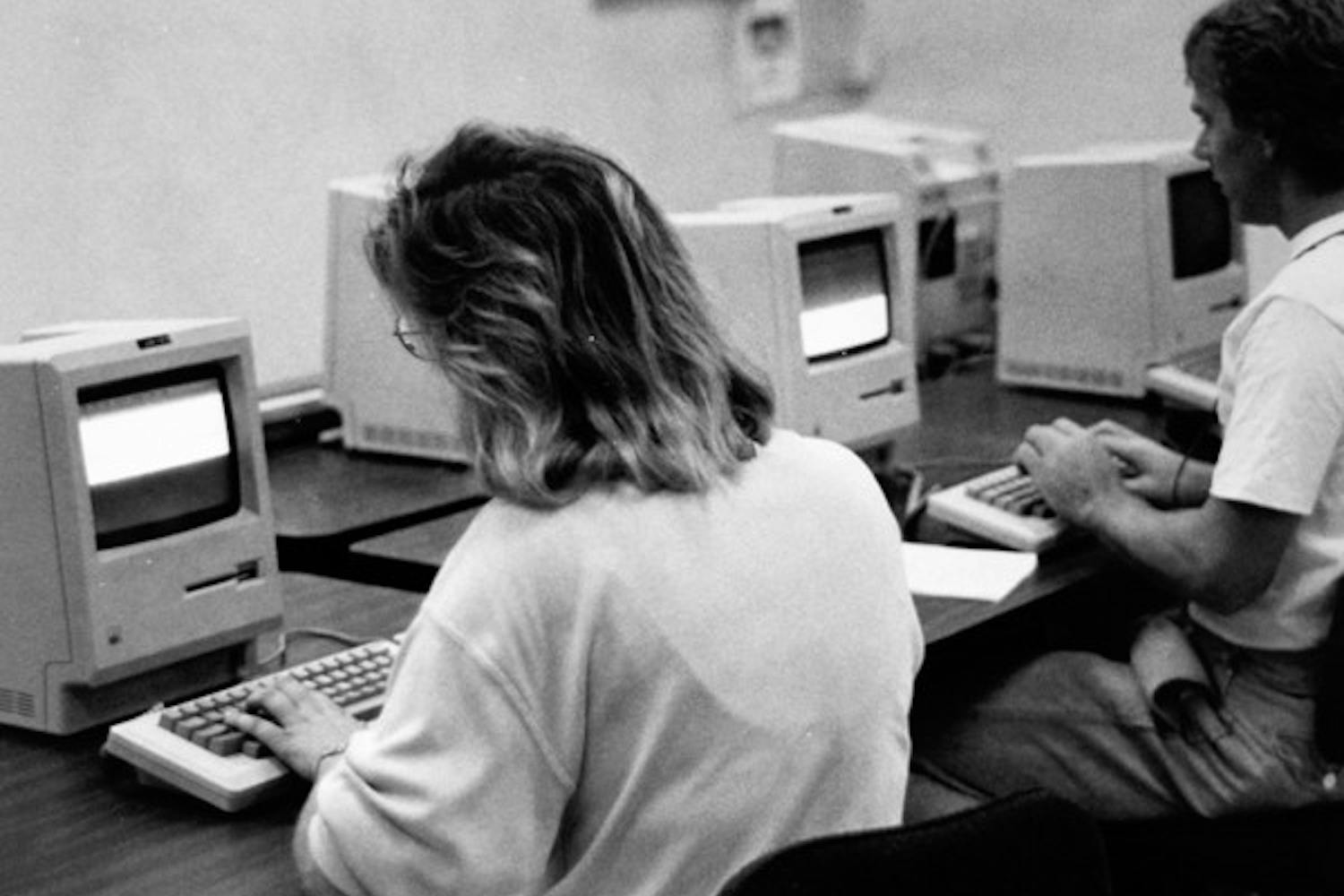 TECHNOLOGY CHANGES FAST: Caryl Grossman, left, and Don Empie, right, use Macintosh computers in their reporting labs in the Journalism department in the ‘80s. (Photo by State Press Photo Staff)