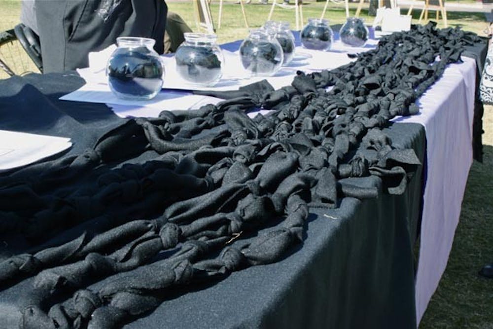 REMEMBERENCE: On Hayden lawn on Thursday, students participated in Transgender Day of Remembrance, with a cloth of black knots. Each knot in the long black cloth represents a death due to hate crimes against transgenders. (Photo by Rosie Gochnour)