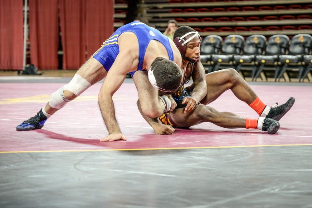 ASU junior Ray Waters and CSU Bakersfield junior Bryce Hammond grapple for control on the mat on Sunday, Jan. 18, 2015, at Wells Fargo Arena in Tempe. The Sun Devils went on to win against the Roadrunners 31 – 6. (J. Bauer-Leffler/The State Press)