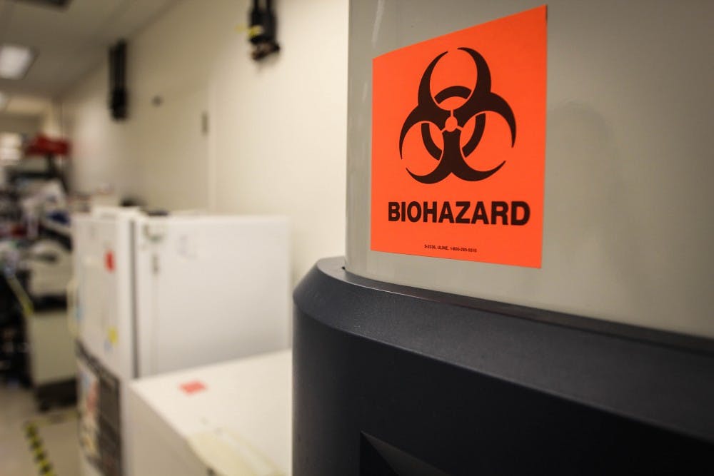 A biohazard sign marks the front of a refrigerator. According to Xiaowei Liu, a team member on a research team at ASU, the refrigerator as been known to handle dangerous cultures of cells and bacteria. (Photo by Dominic Valente)
