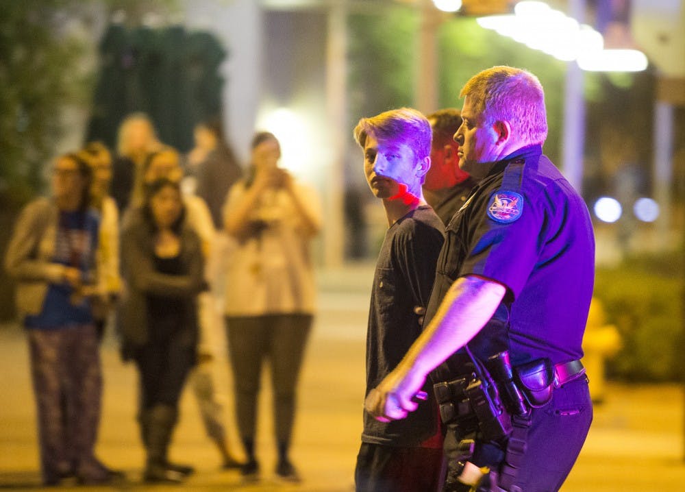 A person is detained outside the currently-under-construction Arizona Center for Law and Society on Sunday, Jan. 17, 2015, in Phoenix, Ariz. Three males were detained by police at the location on 1st Street and Taylor Avenue.
