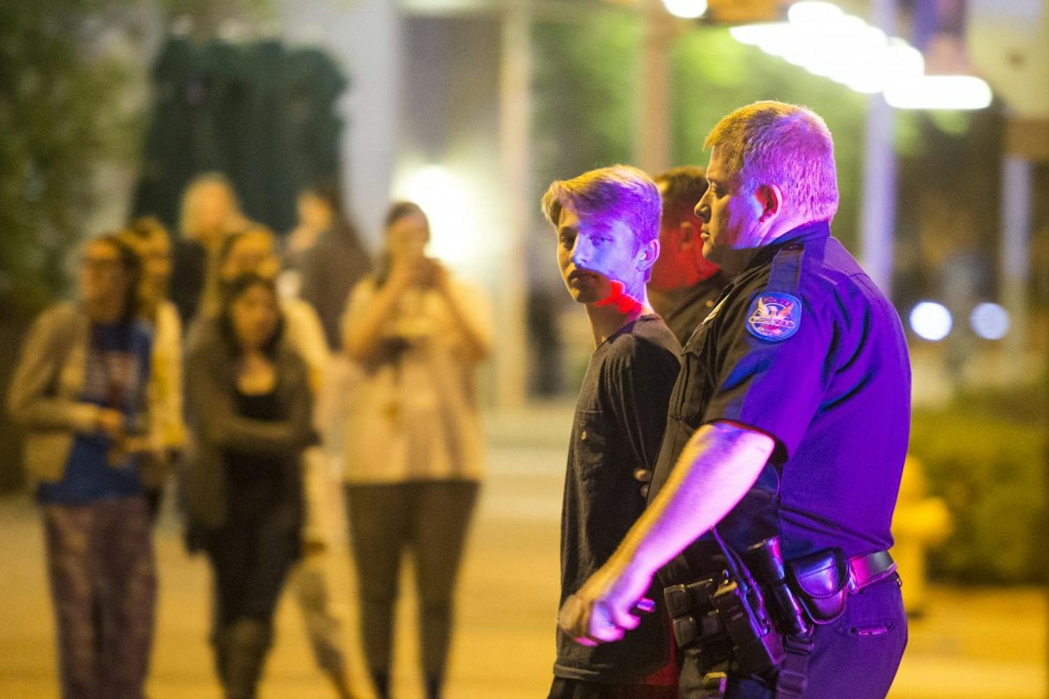 A person is detained outside the currently-under-construction Arizona Center for Law and Society on Sunday, Jan. 17, 2015, in Phoenix, Ariz. Three males were detained by police at the location on 1st Street and Taylor Avenue.