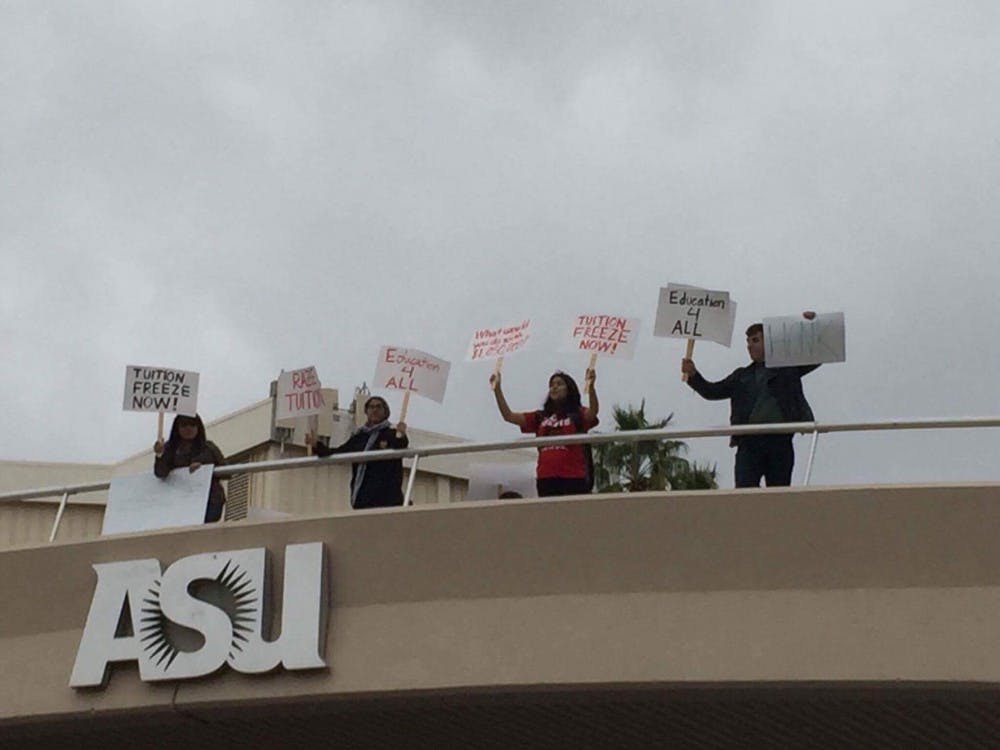 Demonstrators walk across the University Drive pedestrian bridge.