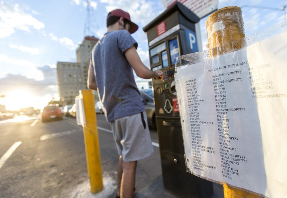 Othman Alishaq, a freshman criminal justice major, pays for his spot in the parking lot on the corner of east Filmore street and north Central avenue on Wednesday, Sept. 28, 2016 
