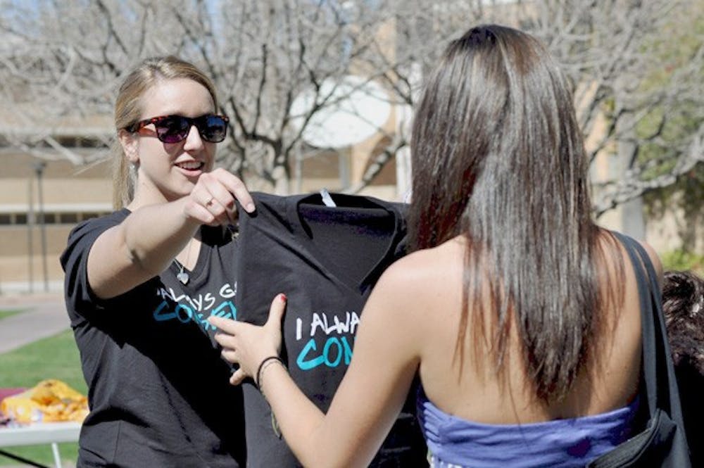 CONSENSUAL AWARENESS: Sophomore political science student Jaclyn Weeman hands out t-shirts that say "I always get consent" to students who promise to only engage in consensual sex. Weeman organized the week's I Always Get Consent events, enlisting the help of friends, acquaintances, and other clubs, after her friend was raped last year. (Photo by Sierra Smith)