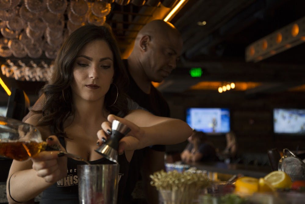 Bartender Bridget Davis 23 makes a drink for a customer at  Whiskey Row on April 7, 2016, on Mill Ave. in Tempe.