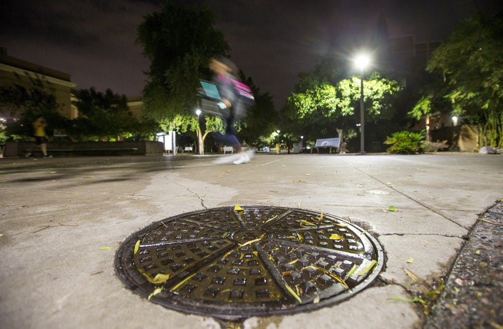 People walk past a storm-access drain on the ASU campus in Tempe, Arizona, on Thursday, Nov. 3, 2016.