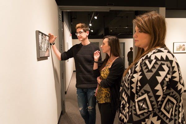 Photography majors Christian Bugarin (left), Robin Sendele (center), and photography and business marketing major Katie Keohan admire a piece of work titled ‘Birds’ by Julia Gonzalez. ASU held an opening reception for The Agency of Ideas at the Northlight Gallery on campus January 28th