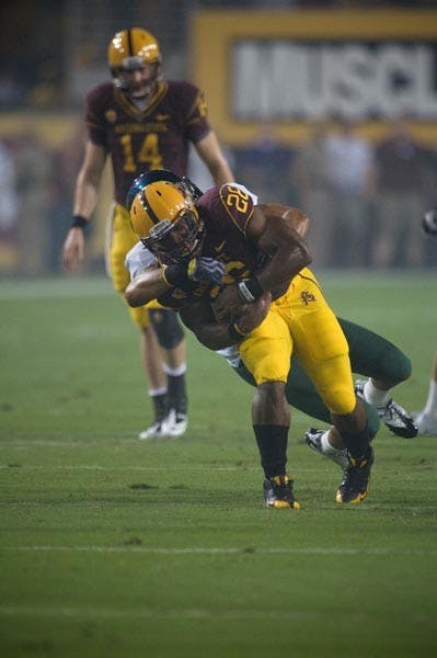 WRAPPED UP: Sophomore running back Cameron Marshall is taken down by an Oregon defender during Saturday's 42-31 loss. Marshall contributed 88 yards but also turned the ball over twice on fumbles. (Photo by Aaron Lavinsky)