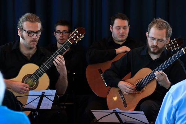 Guitar Performance students Henry Bayless and Robert Greenwald concentrate on their music while performing Roland Chadwick's Flowers for Jerome. This was part of the Performance with a View series featuring the ASU Guitar Ensemble which took place on Tuesday, January 21, 2014. (Photo by Micaela Rodriguez)