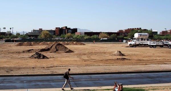 BREAKING GROUND: A student walks past the dirt construction zone where new dorms and a dining hall will be built on the Polytechnic campus. Construction is set to be completed by fall 2012. (Photo by Lisa Bartoli)