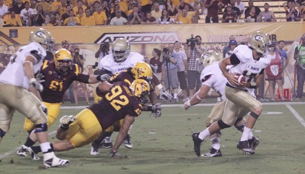 NOT ENOUGH: UC Davis sophomore quarterback Randy Wright runs downfield after breaking a tackle during Thursday’s game. The Aggies executed their game plan, but were no match for the Sun Devil’s speed. (Photo by Beth Easterbrook)