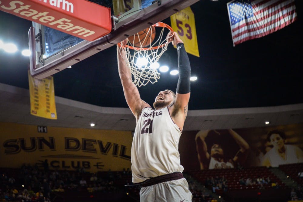 Junior Eric Jacobsen gives a call of victory as he hangs off the rim following his slam dunk on Saturday, Jan. 17, 2015, against the Colorado Buffalos at Wells Fargo Arena in Tempe. The Sun Devils went on to win against the Buffaloes 78-72. (J. Bauer-Leffler/The State Press)