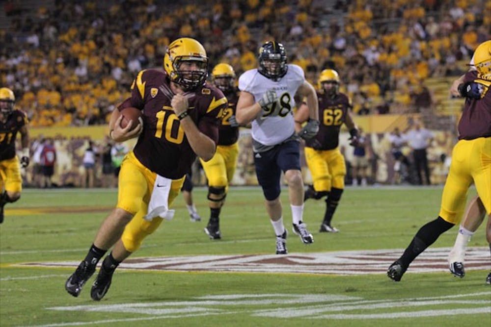 Redshirt sophomore quarterback Taylor Kelly carries the ball past the NAU defense during the Sun Devils’ 63-6 win over the Lumberjacks on Aug. 30. (Photo by Kyle Newman)