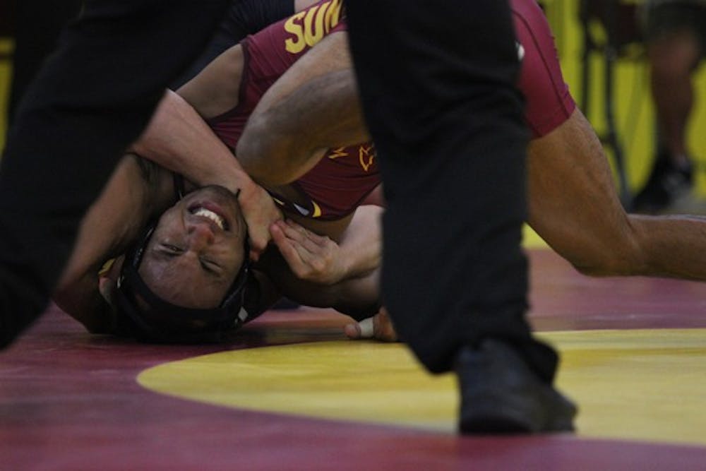 Freshman Ares Carpio struggles under redshirt sophomore Dalton Miller’s lock during the Maroon and Gold Wrestle-Offs last Friday. (Photo by Kyle Newman)