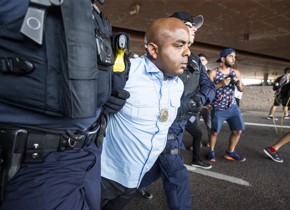 Rev. Jarrett Maupin is arrested during a police-violence protest on the Mill Avenue bridge on Monday, Sept. 26, 2016. Maupin was one of a few people arrested during the event. 