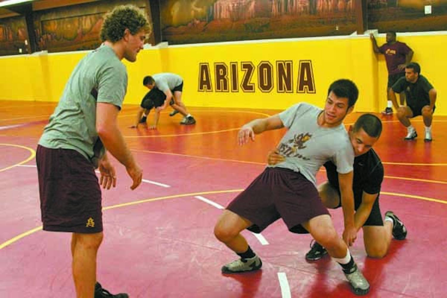 Sharing the Knowledge: After dominating the college stage and competing in the Beijing Olympics, ASU assistant coach Ben Askren (left) now puts his efforts into teaching young wrestlers on the ASU squad. (Photo by Annie Wechter)