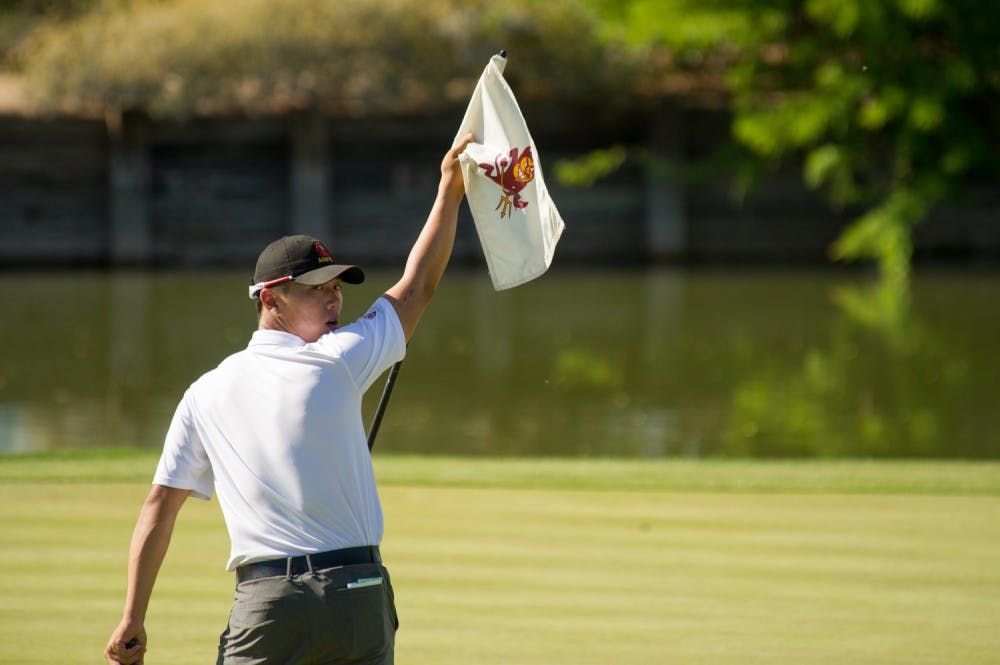 Senior Ki Taek Lee holds the flag while the other players in his pairing complete the round of play during the ASU Thunderbird Invitational on Saturday, April 2, 2016 at Karsten Golf Course in Tempe, Arizona.