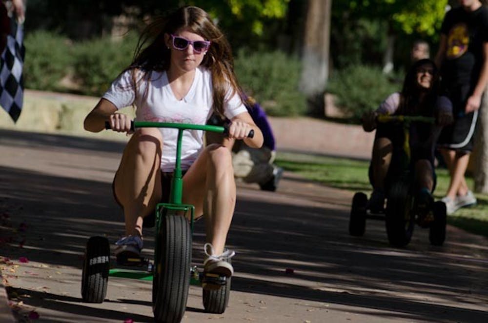TRIKING FOR A CAUSE: Hannah Grivna, a junior communication and event planning major and member of Gamma Phi Beta Sorority, races for Trike-la-tron 2010, a Greek Life cancer fundraiser. (Photo by Aaron Lavinsky)