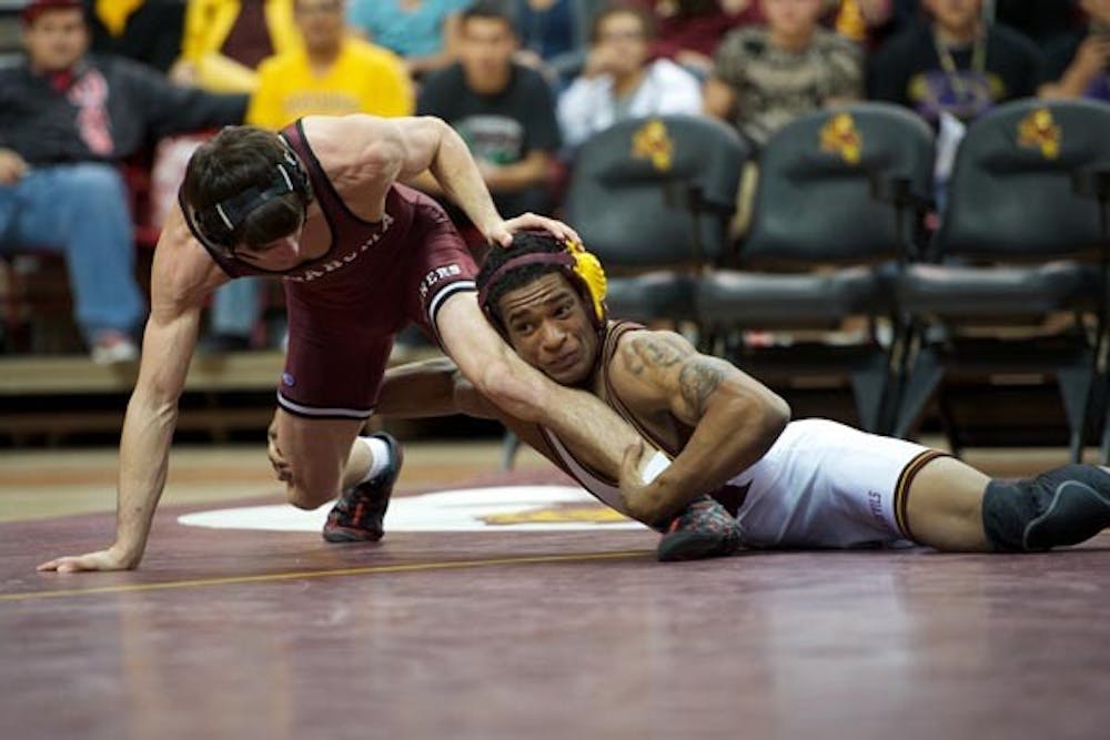 SOONER SLAUGHTER: Senior Anthony Robles tries to bring down Oklahoma sophomore Jarrod Patterson during a match Thursday night. Robles won the match 16-1, but the Sun Devils lost the dual to the No. 8 Sooners as only Robles and fellow senior Bubba Jenkins won their matches. (Photo by Michael Arellano)