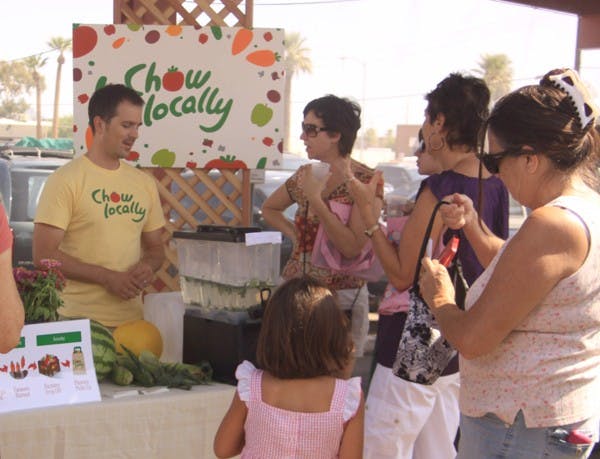 FARM TO TABLE: Chris Wharton of Chow Locally spends time talking with customers at the Public Market on Saturday morning. The three-week-old company allows people to order farmer's products online and pick-up their orders Saturday mornings at the Public Market in Downtown Phoenix. (Photo by Lillian Reid)