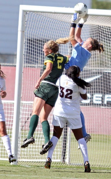 STAYING STRONG: Junior goalkeeper Alyssa Gillmore (ball) catches the ball in the box while Oregon redshirt junior defender Lauren Thompson runs for a header during the Sun Devils’ 4-0 win over the Ducks. (Photo courtesy of Steve Rodriguez)