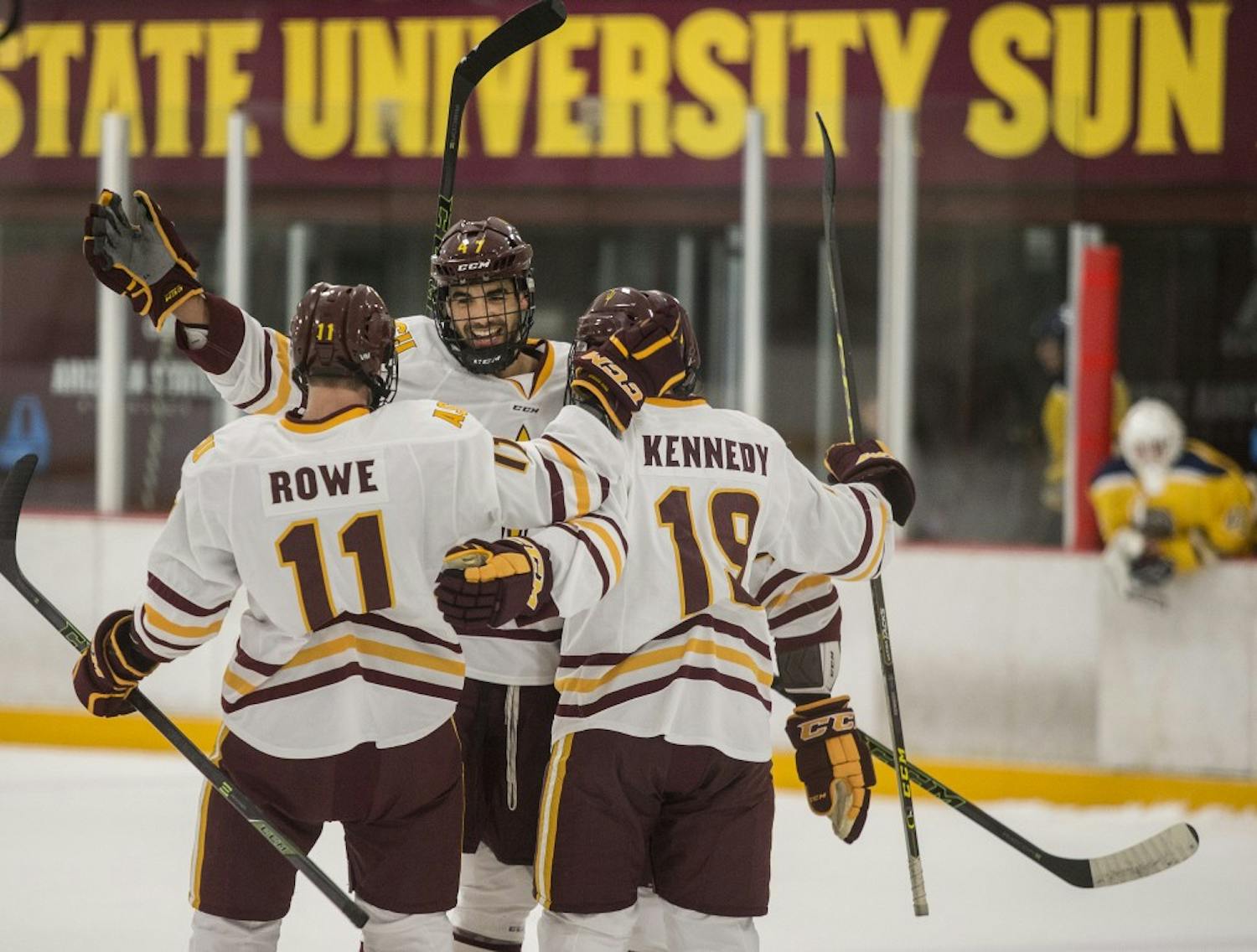 Left wing Jack Rowe, left, and center Matt Kennedy, right, celebrate a goal by defender Nicholas Gushue, center, during a game at the Oceanside Ice Arena in Tempe, Ariz. The Sun Devils lead Southern New Hampshire 4-1 after the first period. 